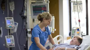 Katie Miller, RN comforts patient in the SICU at Tufts Medical Center.