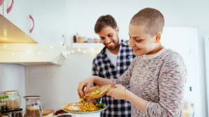 Cancer patient cooking a healthy and nutritious meal at home with their partner.