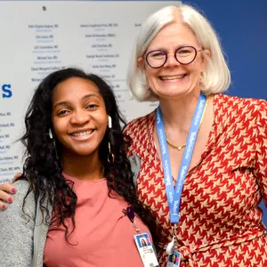 Tufts Medical Center's Associate Chief Medical Officer, Kari Roberts, MD, takes photo with a graduate during the GME residents and fellows graduation.