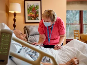 Diane Fumia, RN checking hospice patient's heart with a stethoscope at Care at Home's High Point House.