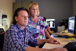 CT Scan Technologists, Almir Bulic and Jan Stone reviewing a CT scan on a computer screen.